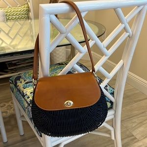 J McLaughlin navy blue rattan shoulder bag with Brown leather strap and accents.
